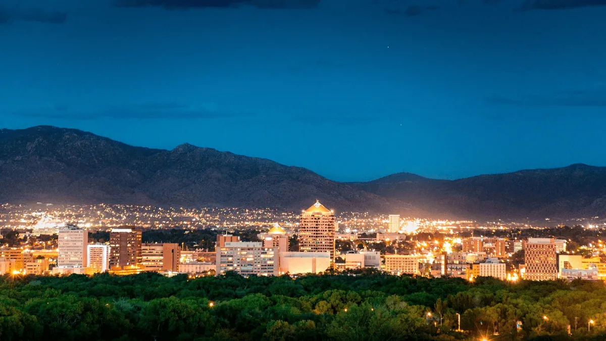 Albuquerque New Mexico cityscape with Sandia Mountains in background at sunset with desert landscape