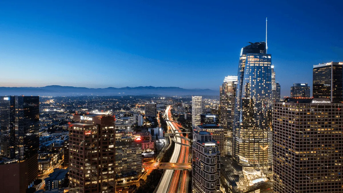 Los Angeles California downtown skyline with palm trees and San Gabriel Mountains at golden hour