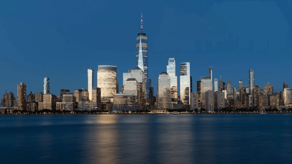 New York City Manhattan skyline featuring the Empire State Building, One World Trade Center, and Brooklyn Bridge at twilight