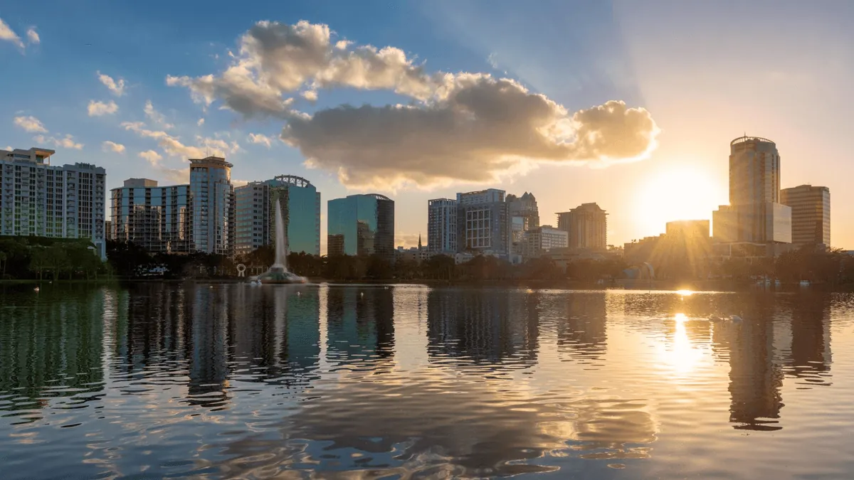 Orlando Florida downtown skyline with Lake Eola fountain and palm trees at dusk